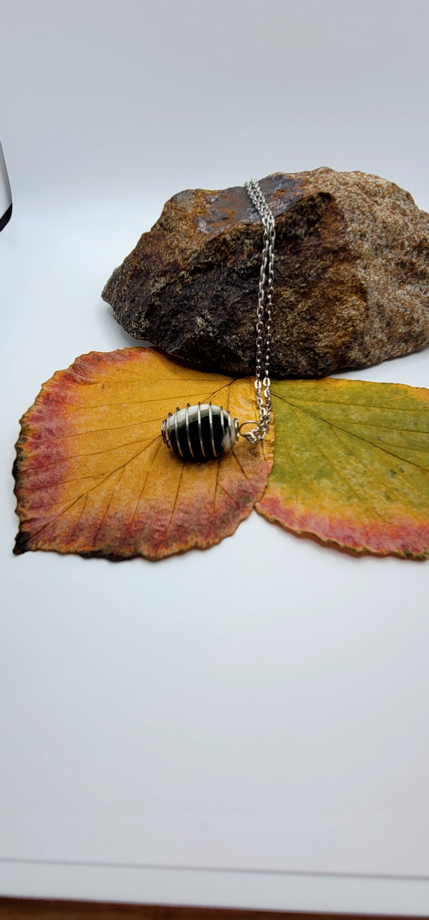 This Green and White Opal Stone is enclosed in a spiral cage, combining to create an elegant look. Make this the perfect gift for mom, dad, sister, brother, friend or other relative. You'll be glad you did.