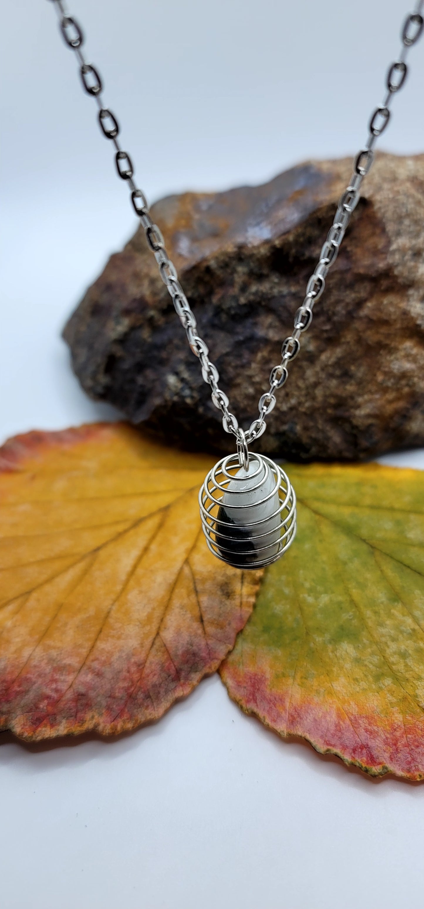 This Green and White Opal Stone is enclosed in a spiral cage, combining to create an elegant look. Make this the perfect gift for mom, dad, sister, brother, friend or other relative. You'll be glad you did.