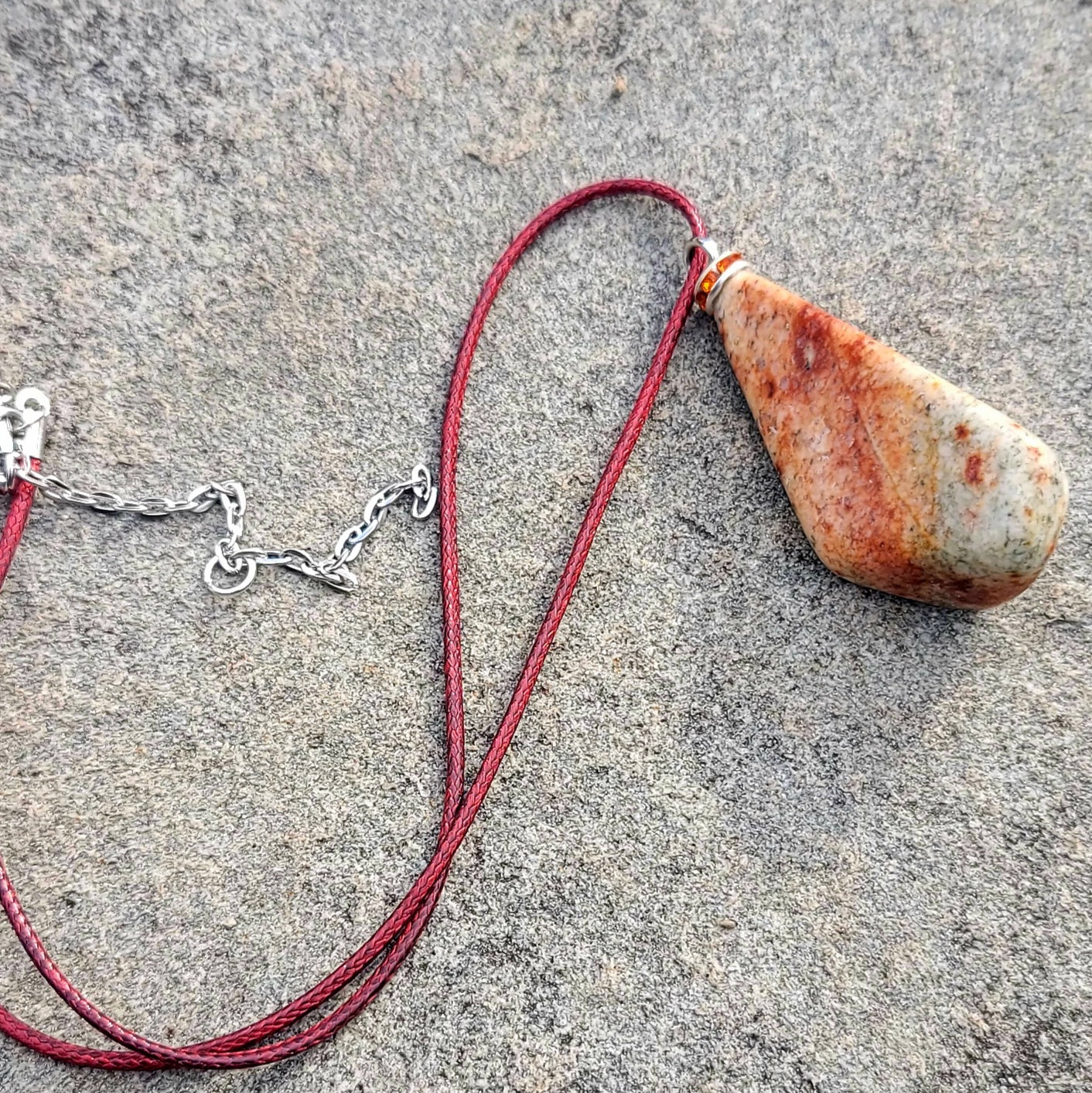 Very unique and powerful sunstone pendant. This stone has an intriguing color pattern consisting of Reds, Oranges, Green and Brown. It also has a unique shape that will definitely stand out. This is a true one-of-a-kind piece.