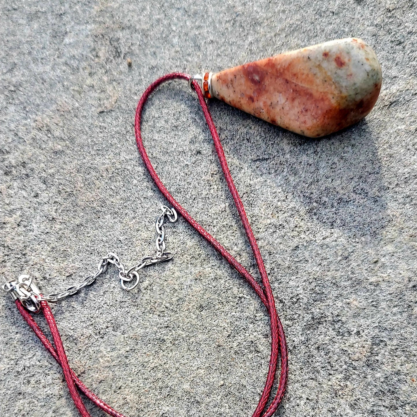 Very unique and powerful sunstone pendant. This stone has an intriguing color pattern consisting of Reds, Oranges, Green and Brown. It also has a unique shape that will definitely stand out. This is a true one-of-a-kind piece.