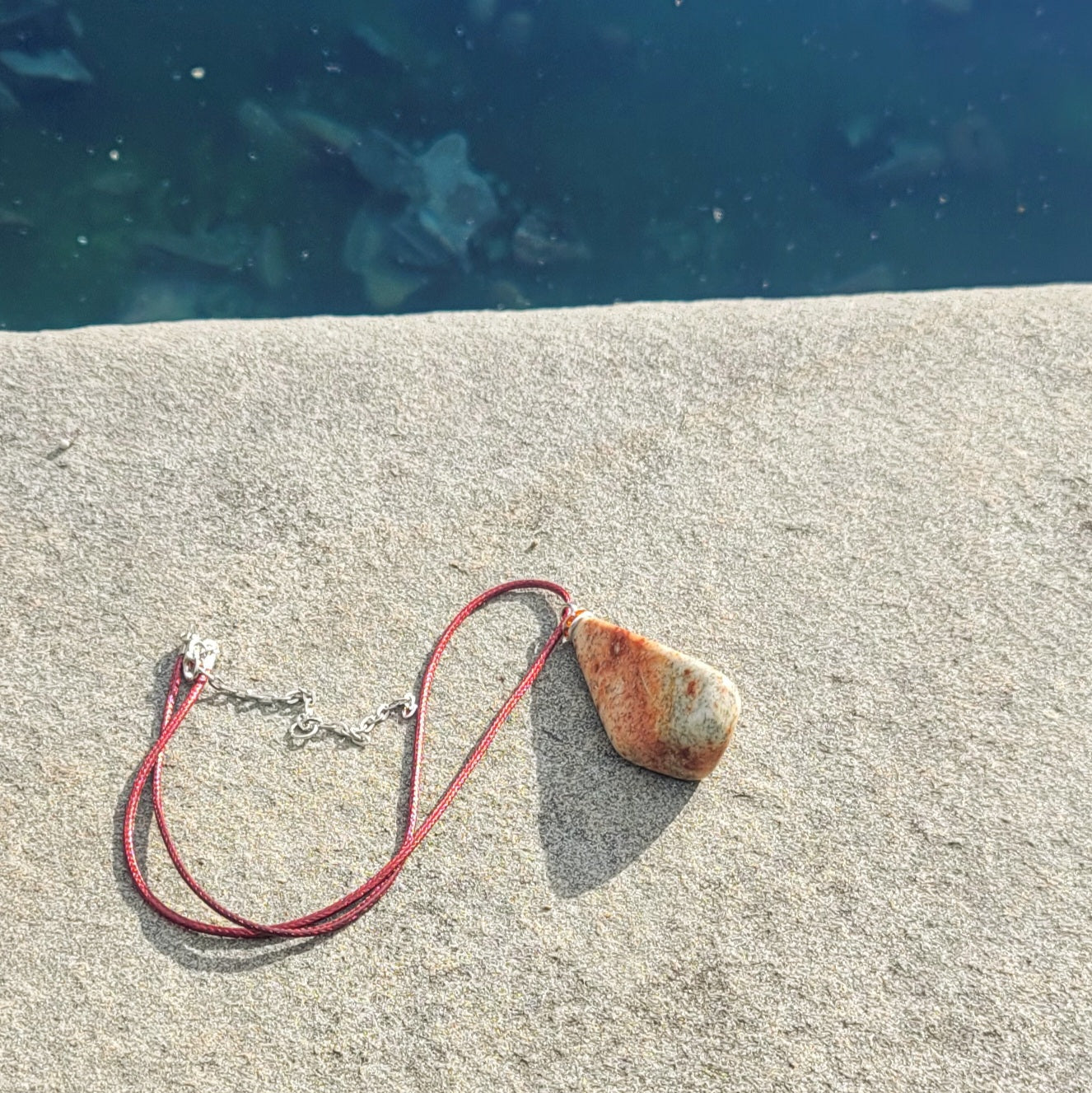 Very unique and powerful sunstone pendant. This stone has an intriguing color pattern consisting of Reds, Oranges, Green and Brown. It also has a unique shape that will definitely stand out. This is a true one-of-a-kind piece.