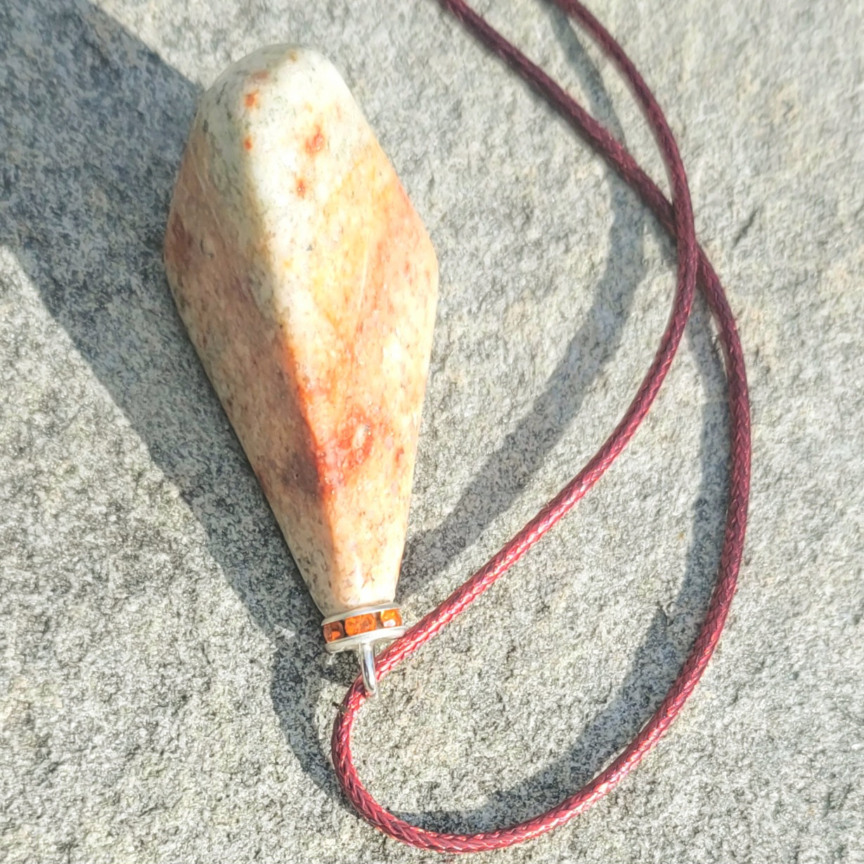 Very unique and powerful sunstone pendant. This stone has an intriguing color pattern consisting of Reds, Oranges, Green and Brown. It also has a unique shape that will definitely stand out. This is a true one-of-a-kind piece.