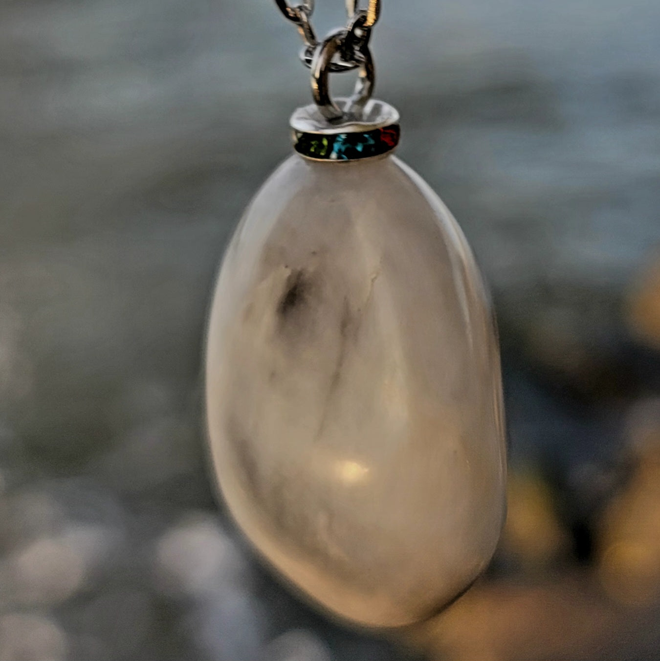 BEAUTIFUL WHITE QUARTZ GEMSTONE PENDANT WITH TRACES OF RED AND BLACK.