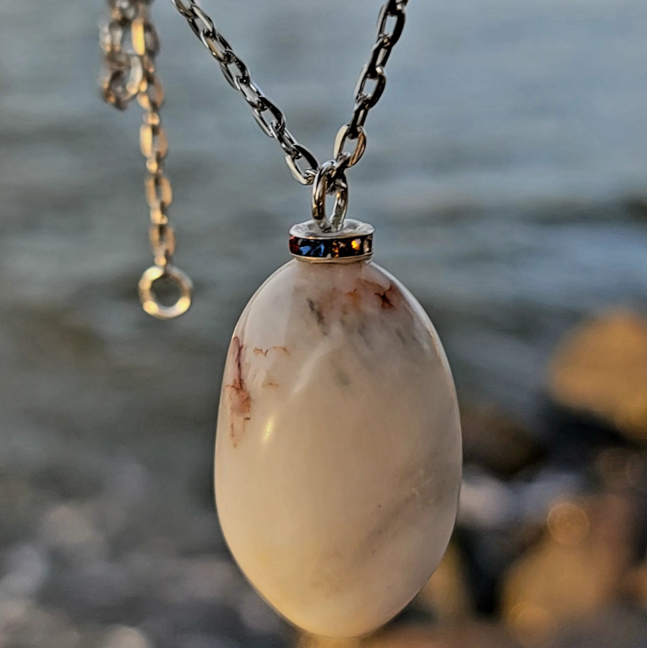 BEAUTIFUL WHITE QUARTZ GEMSTONE PENDANT WITH TRACES OF RED AND BLACK.