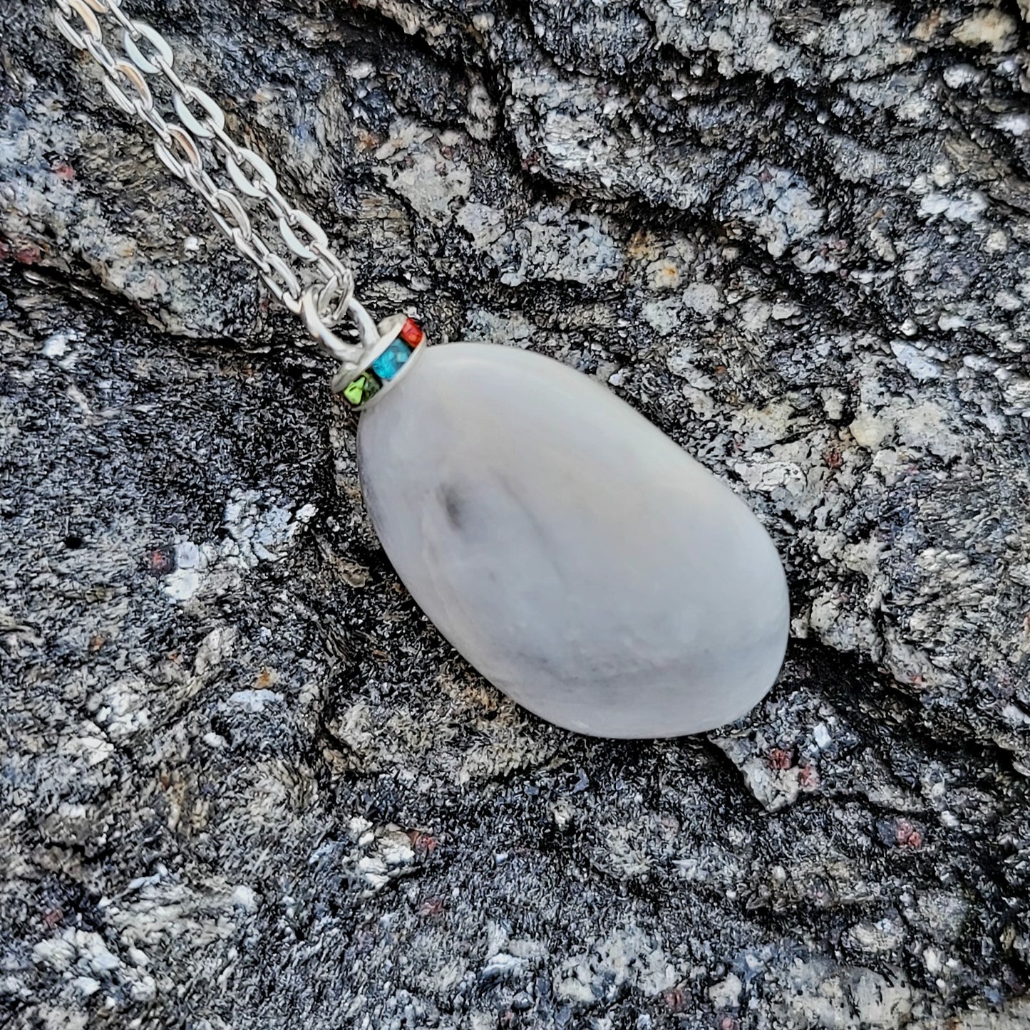 BEAUTIFUL WHITE QUARTZ GEMSTONE PENDANT WITH TRACES OF RED AND BLACK.