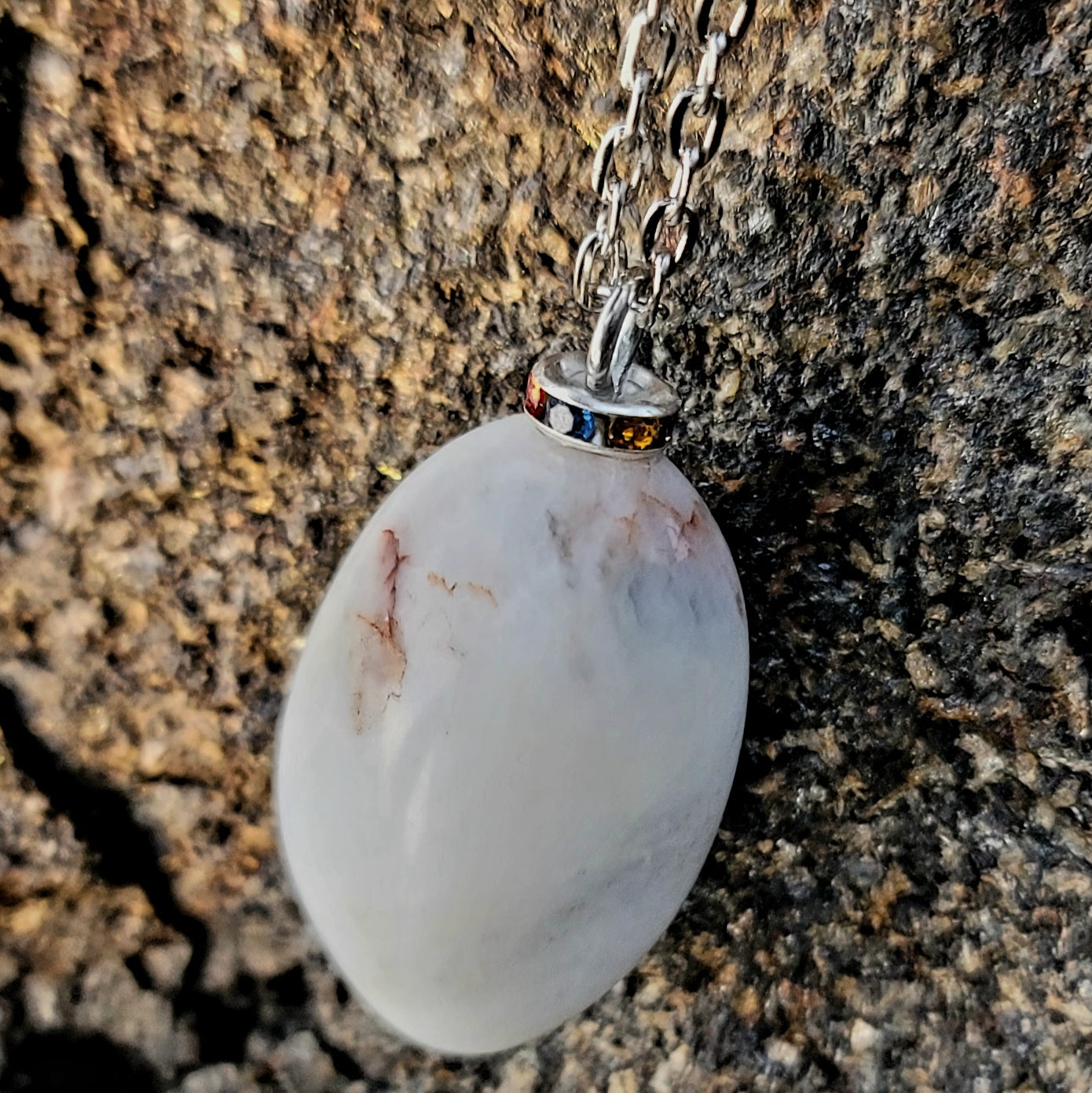 BEAUTIFUL WHITE QUARTZ GEMSTONE PENDANT WITH TRACES OF RED AND BLACK.