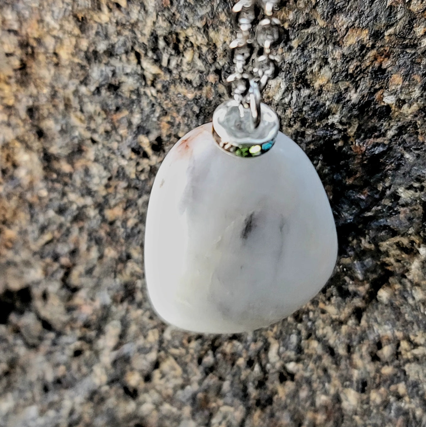 BEAUTIFUL WHITE QUARTZ GEMSTONE PENDANT WITH TRACES OF RED AND BLACK.