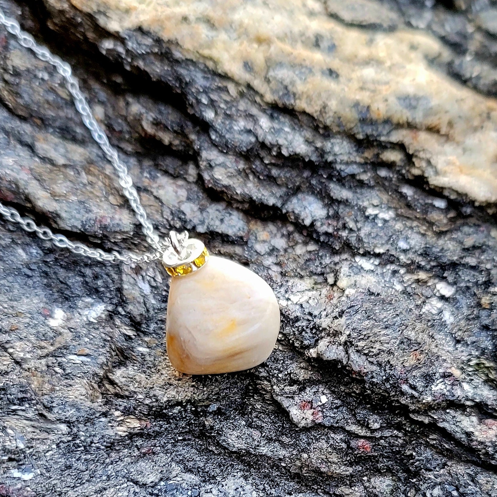 This intricately crafted zebra marble gemstone pendant is a one-of-a-kind masterpiece. Meticulously cut and polished to create an elegant pattern of black, yellow and white striped patterns. This pendant is trimmed with a stainless steel, 20" chain.