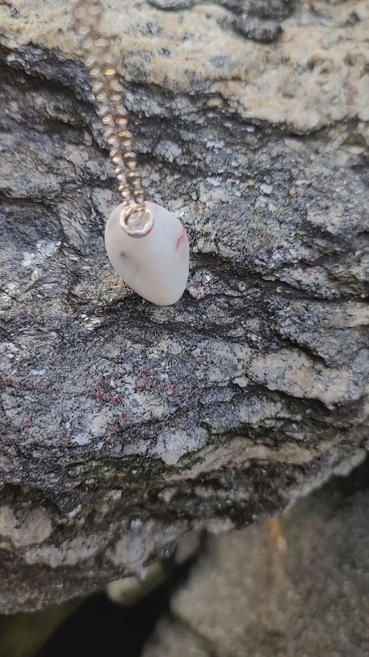 BEAUTIFUL WHITE QUARTZ GEMSTONE PENDANT WITH TRACES OF RED AND BLACK.