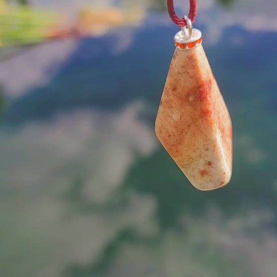 Very unique and powerful sunstone pendant. This stone has an intriguing color pattern consisting of Reds, Oranges, Green and Brown. It also has a unique shape that will definitely stand out. This is a true one-of-a-kind piece. Pictured in video, hanging.