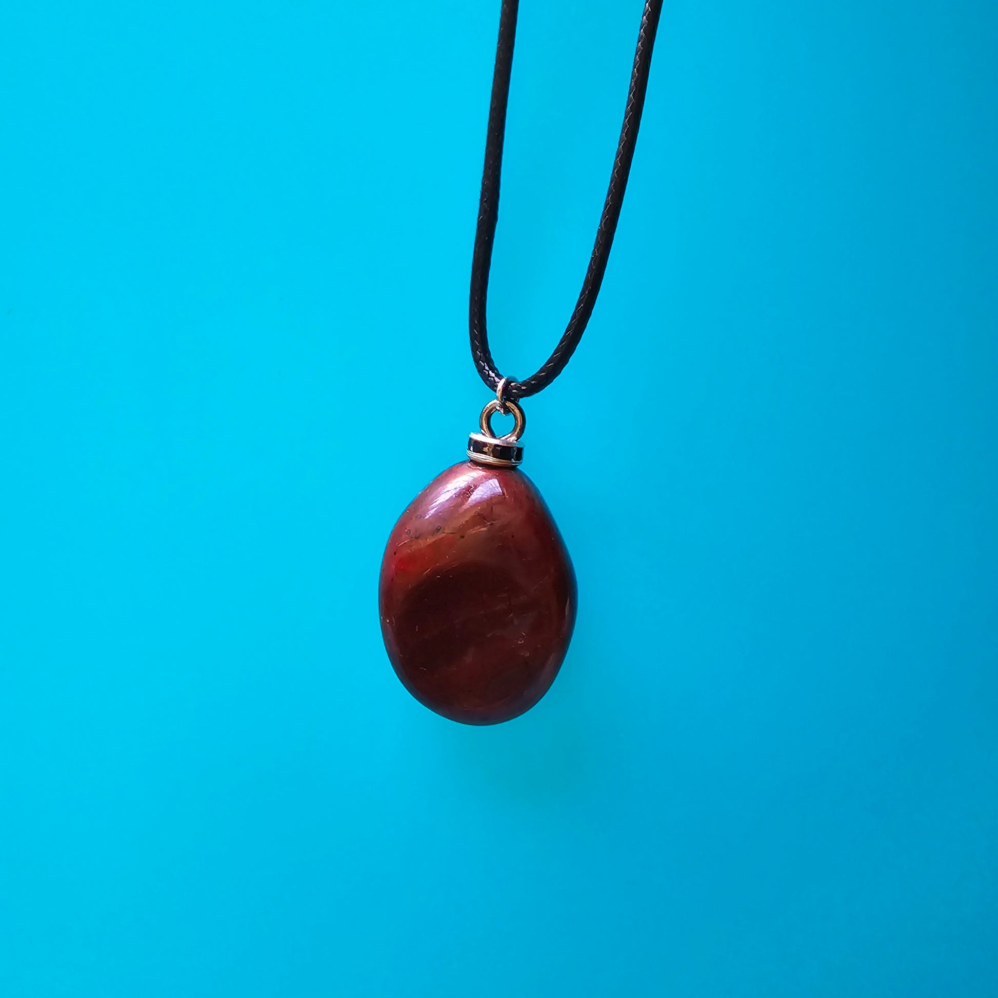 Beautiful and intricate Red Jasper Pendant. Finished with Black and Silver trim and an 18" Polyester string.