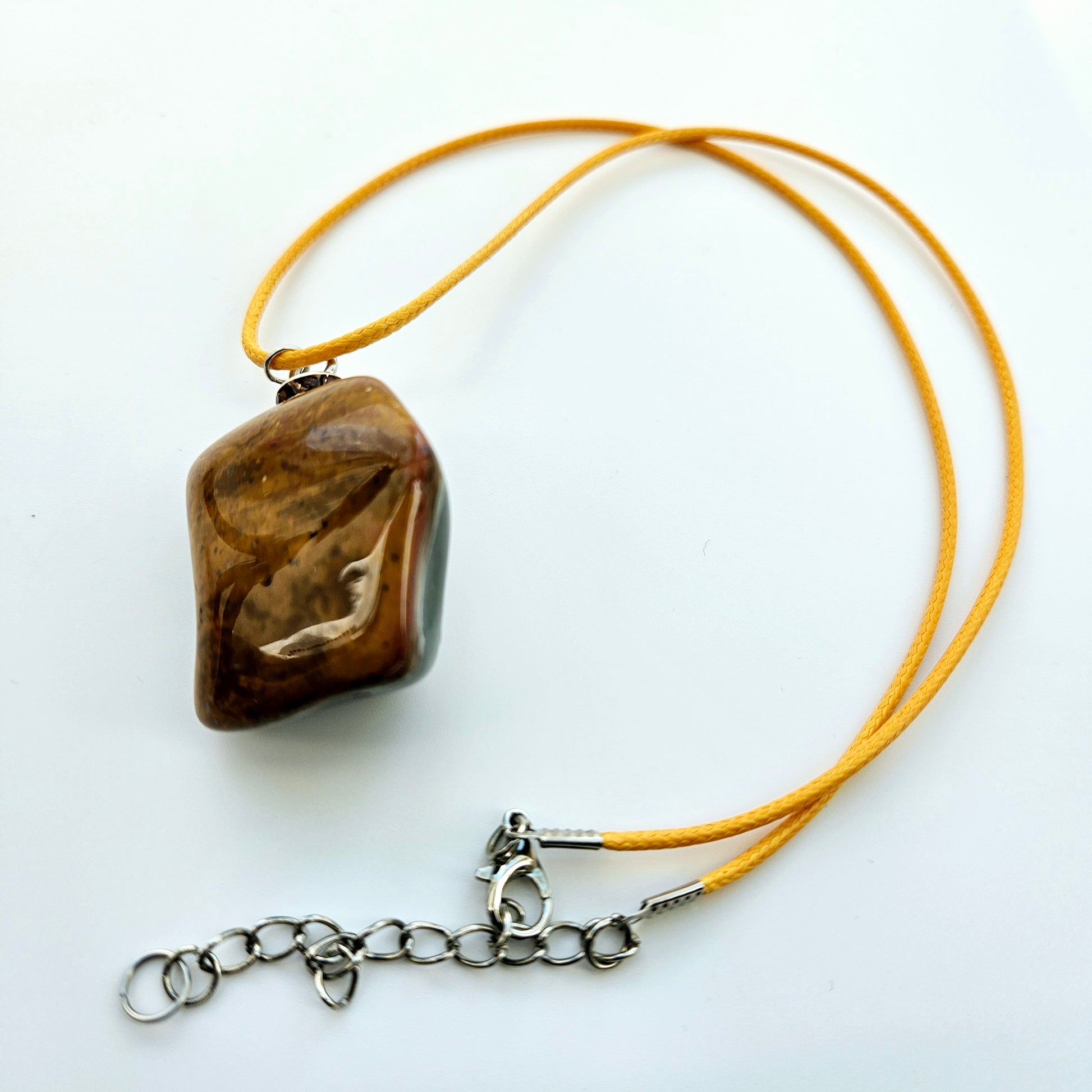 Unique and bold Desert Jasper Pendant with a very intricate color pattern. You will be amazed by its stunning beauty. It is finished with a Yellow Polyester string.