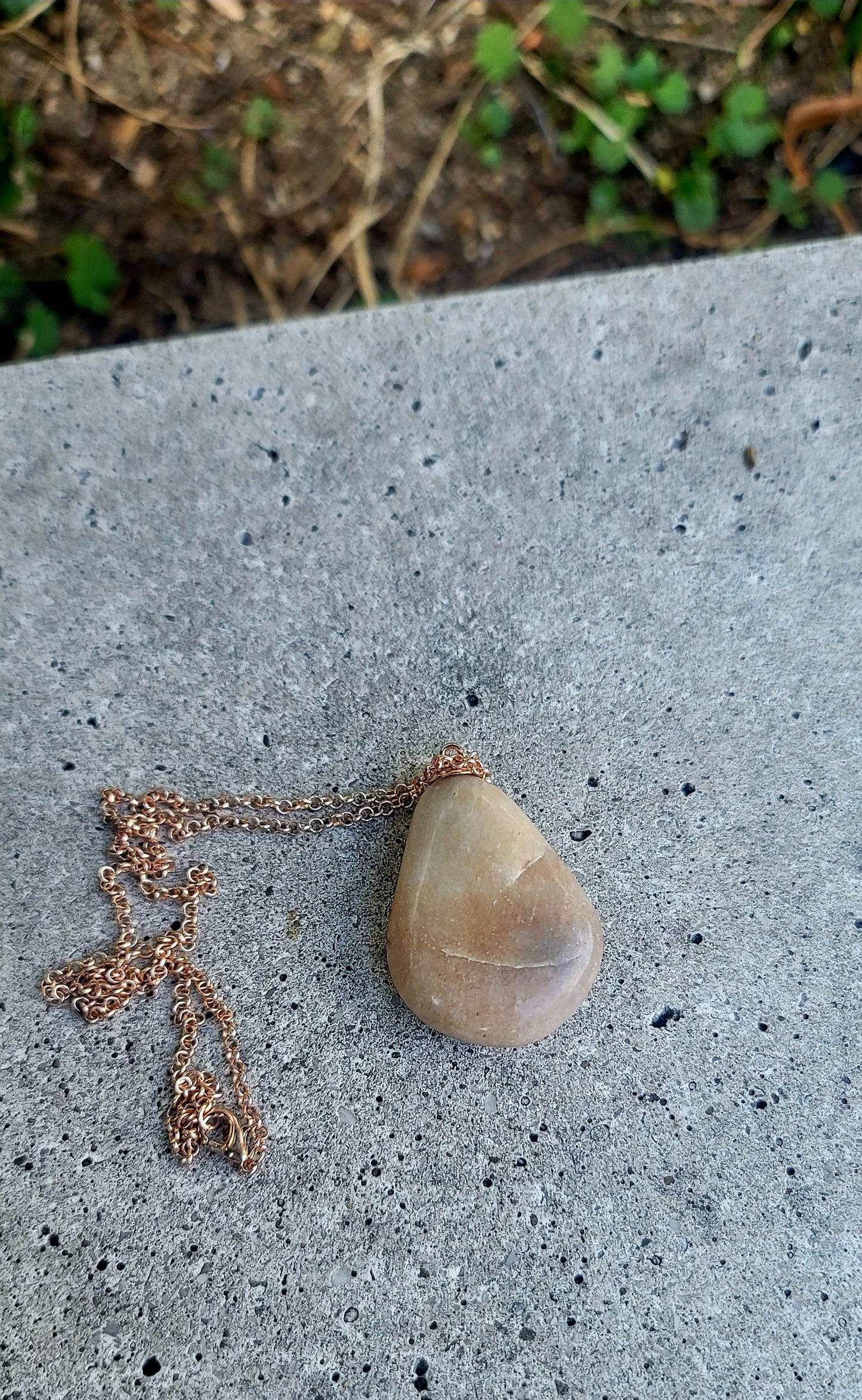 Teardrop-shaped, tan and brown colored Quartz gemstone pendant. Copper plated chain