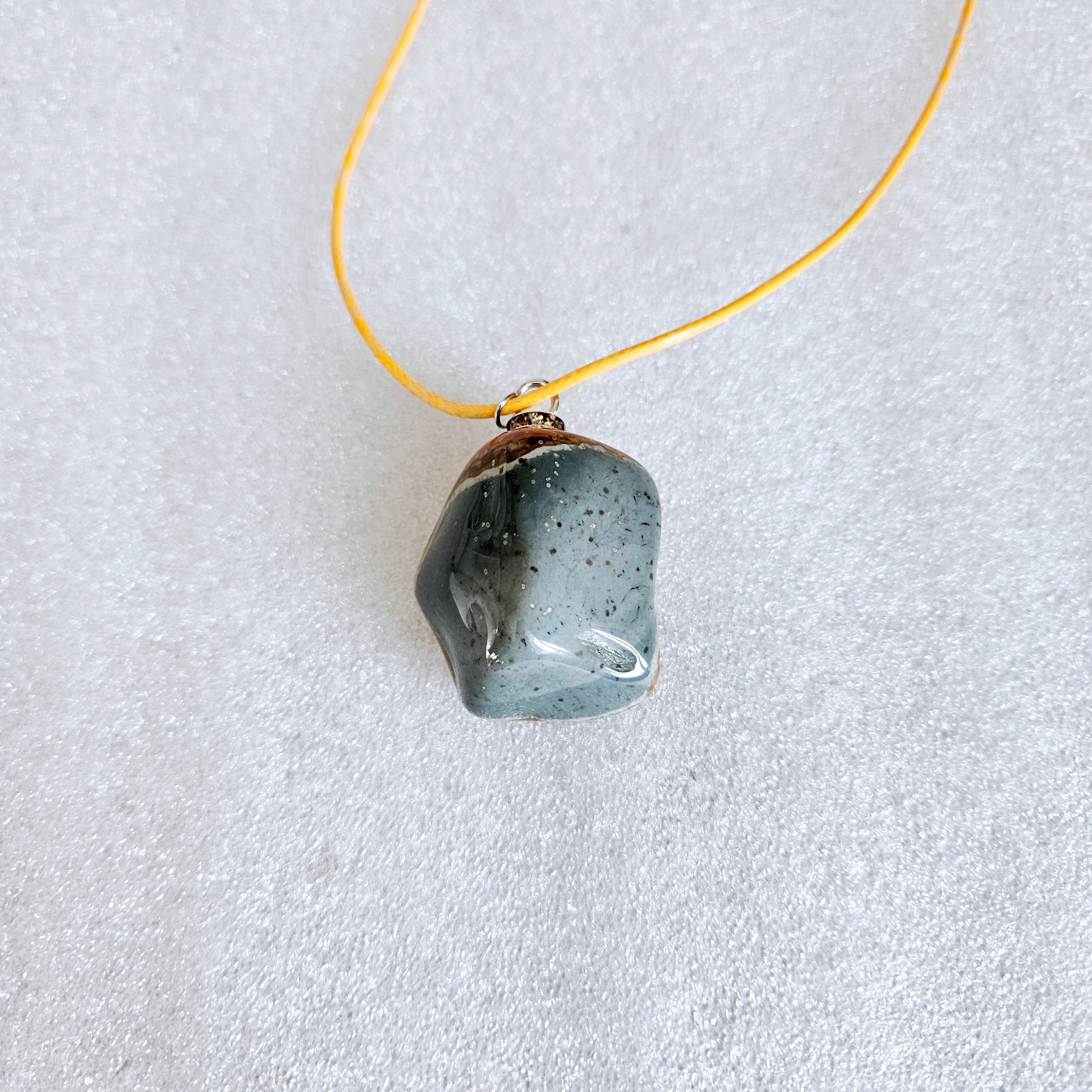 Unique and bold Desert Jasper Pendant with a very intricate color pattern. You will be amazed by its stunning beauty. It is finished with a Yellow Polyester string.