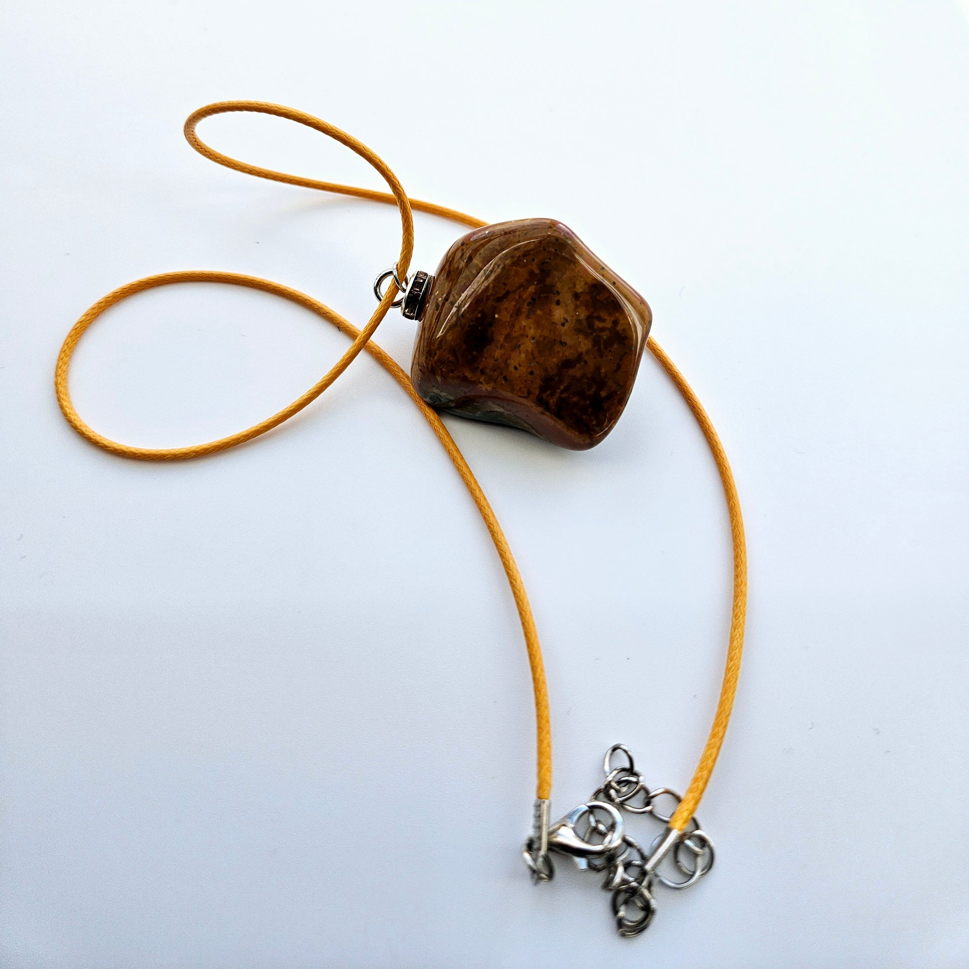 Unique and bold Desert Jasper Pendant with a very intricate color pattern. You will be amazed by its stunning beauty. It is finished with a Yellow Polyester string.