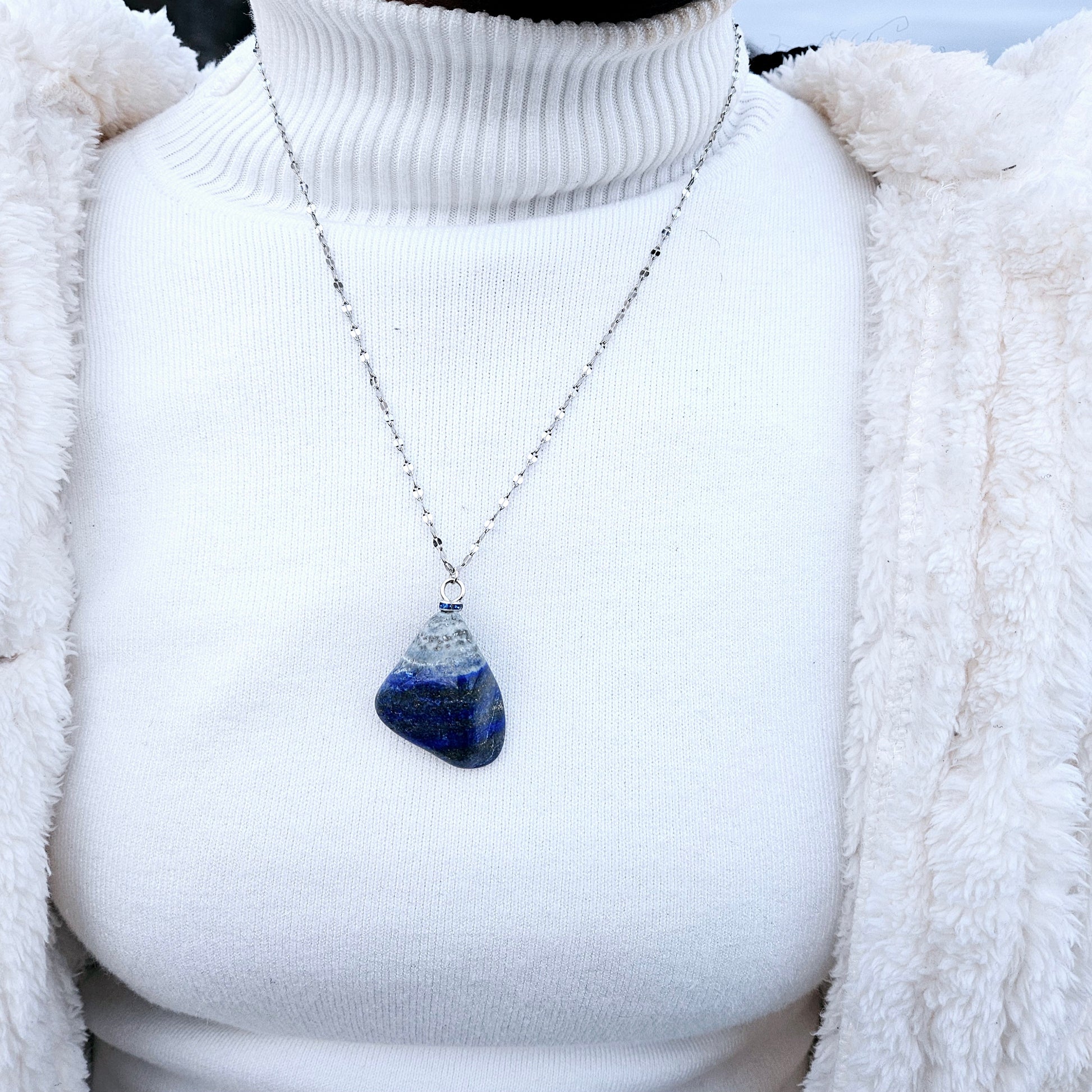 Striking Lapis Lazuli Pendant with deep hues of Blue and Greys. It is trimmed with Silver-Plated findings and a 20" sterling Silver chain.