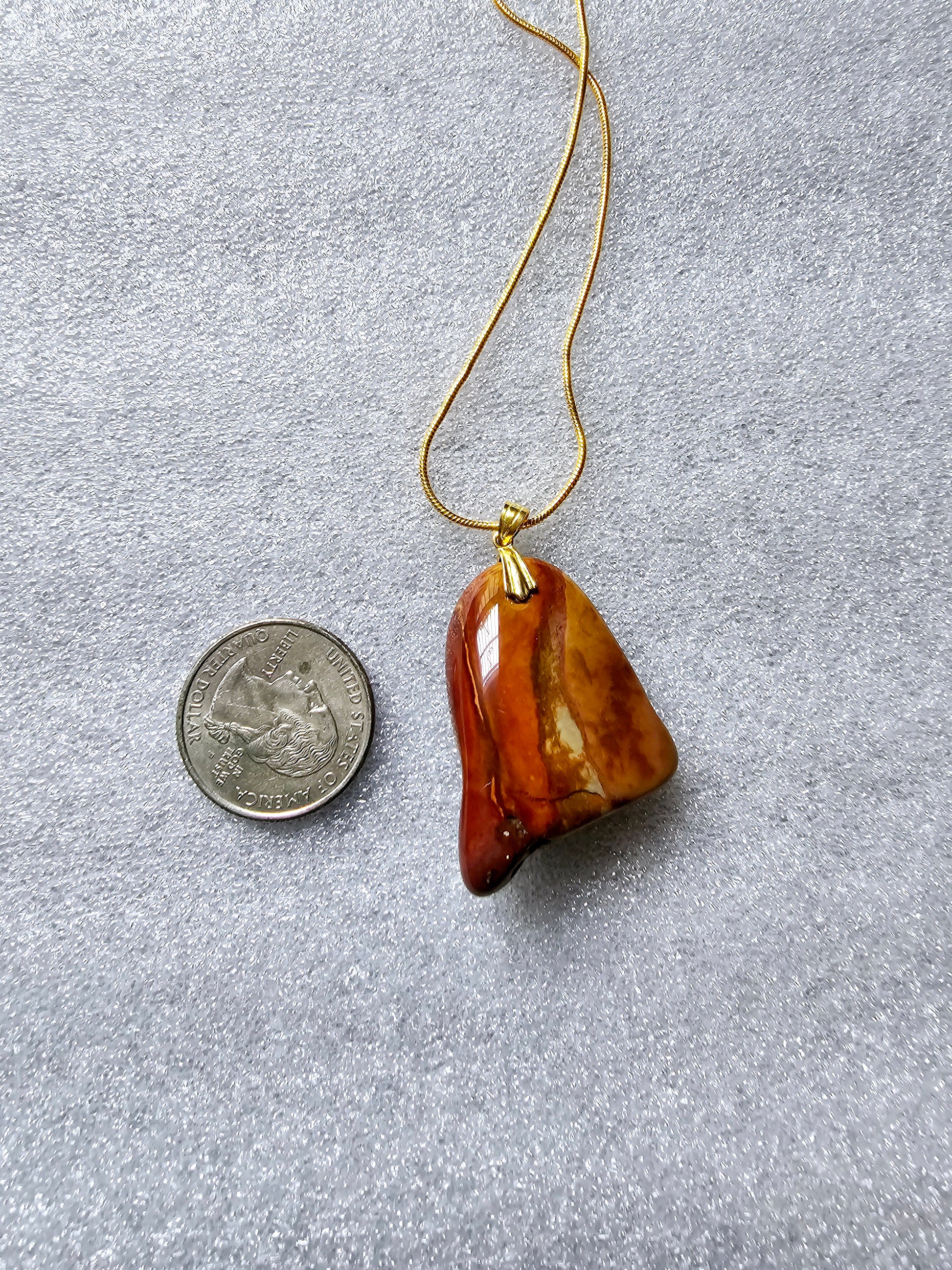 A stunning beauty of our Desert Jasper Pendant. This unique stone features a mesmerizing color pattern and is known for its powerful metaphysical properties. It promotes inner peace, balance and protection while enhancing creativity and self-expression. Backside shown with US quarter for size reference.