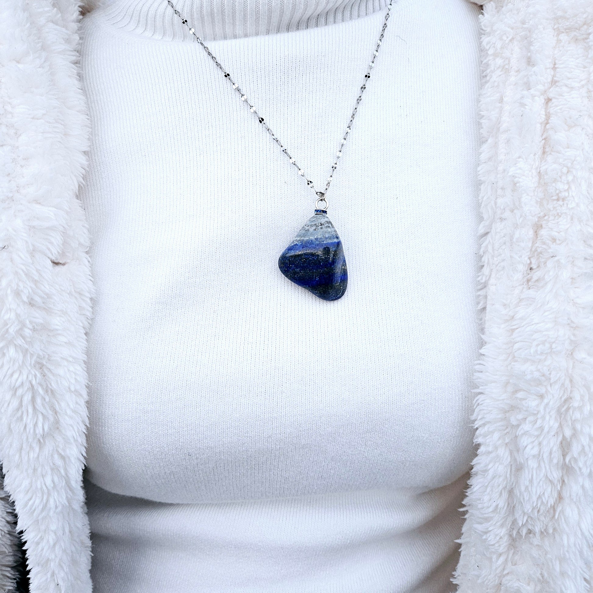 Striking Lapis Lazuli Pendant with deep hues of Blue and Greys. It is trimmed with Silver-Plated findings and a 20" sterling Silver chain.